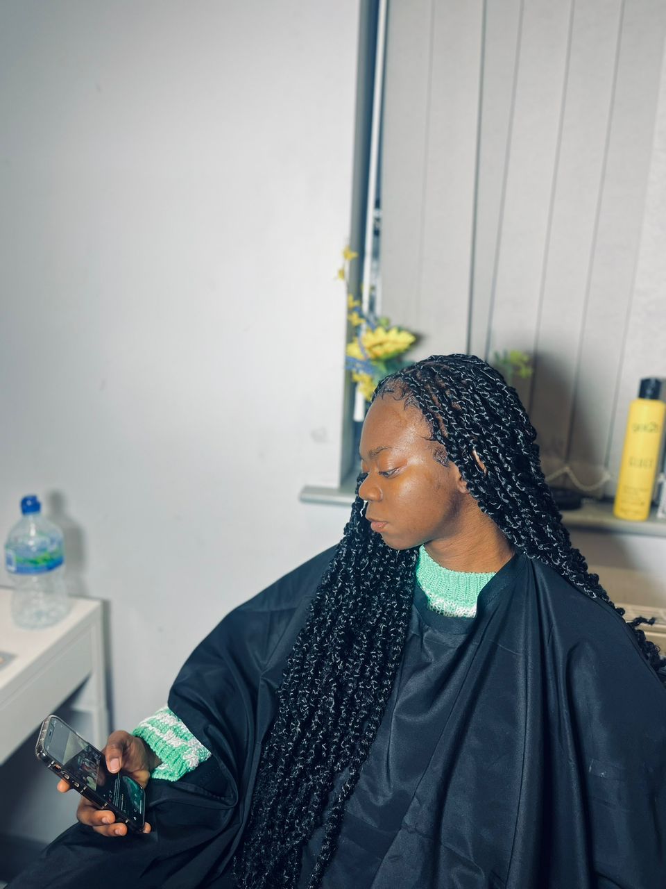 A client relaxing in the studio chair with freshly finished knotless braids.
